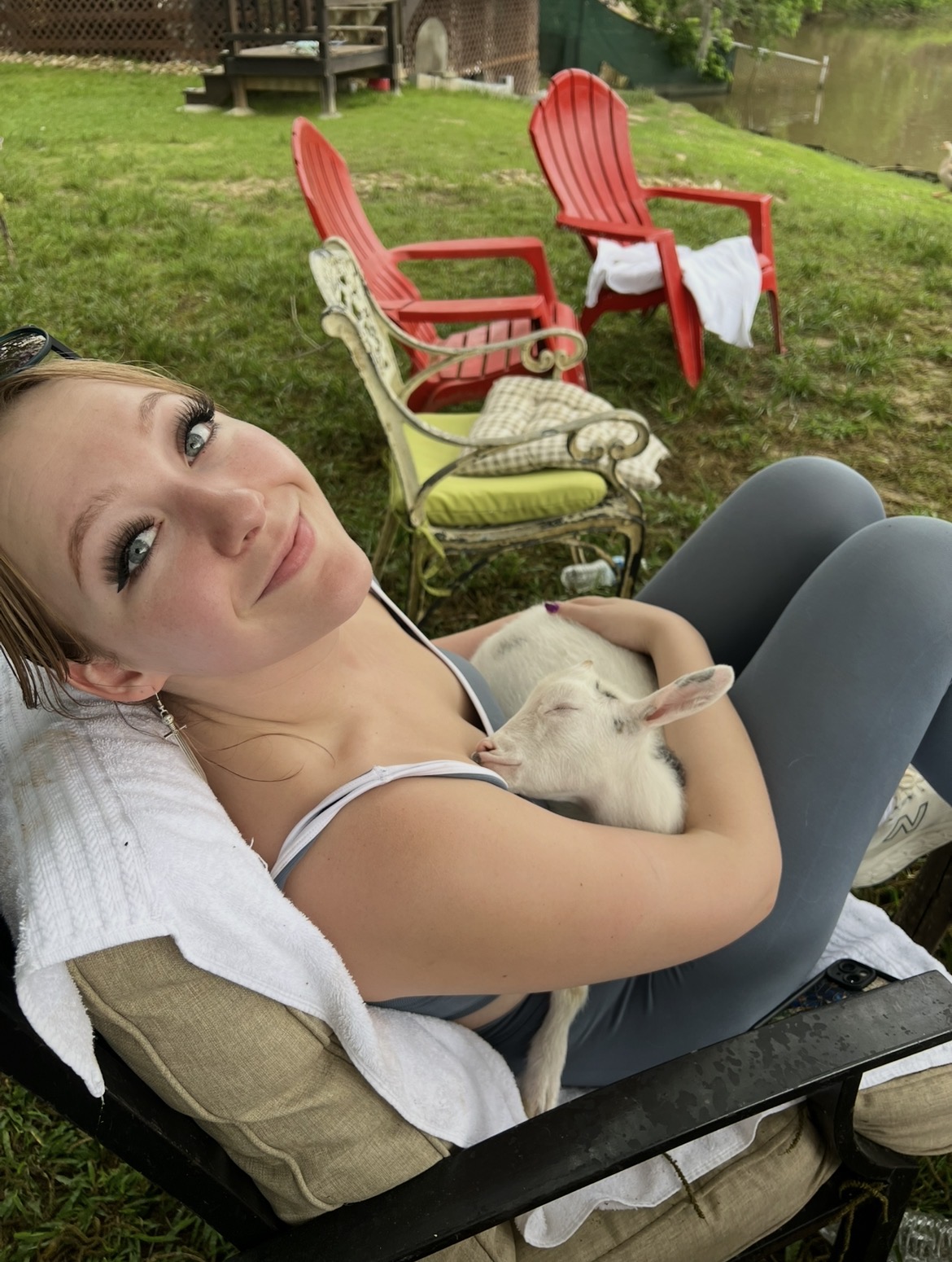 A guest cuddling a sleeping baby goat